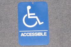 Sign-symbol of wheelchair with ACCESSIBLE + braille lettering, stock number S-1238